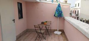 a table and chairs and an umbrella on a balcony at Via Pisa 20 Mansarda in Bari