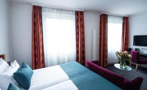 a hotel room with a bed and a window at The Ambassador in Geneva