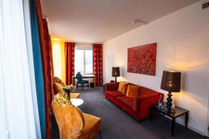 a living room with a red couch and a table at The Ambassador in Geneva