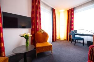 a hotel room with a chair and a table at The Ambassador in Geneva
