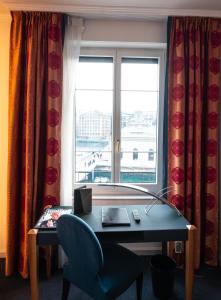a desk and a chair in a room with a window at The Ambassador in Geneva