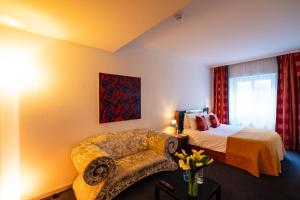 a hotel room with a bed and a chair at The Ambassador in Geneva