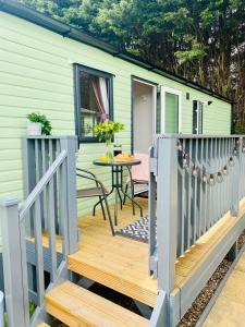 a tiny house with a deck with a table at Nook on the Nidd, Knaresborough in Knaresborough