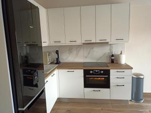 a kitchen with white cabinets and a stove top oven at Paparoúna 5 min from beach in Nikiti