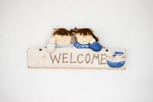 a welcome sign with two dolls hugging at Solaris in Chora Folegandros