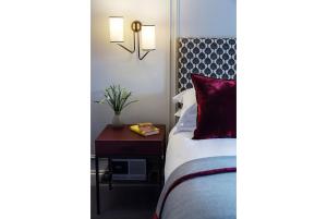 a bedroom with a bed with a red pillow and a table at Old Parsonage Hotel in Oxford