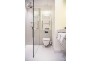 a bathroom with a toilet and a glass shower at Old Parsonage Hotel in Oxford