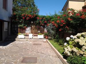 een tuin met rode bloemen op een hek en een patio bij La terrazza di Elena in Abbadia San Salvatore
