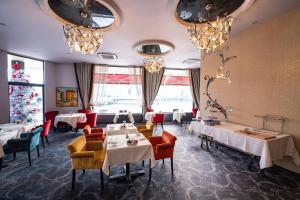 a dining room with tables and chairs and chandeliers at The Ambassador in Geneva