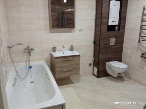 La salle de bains est pourvue d'une baignoire, de toilettes et d'un lavabo. dans l'établissement Vanalinna Apartment, à Narva