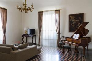 - un salon avec un piano et un canapé dans l'établissement Don Giovanni Charme Apartment, à Catane