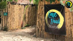 een bord op een hek met een bord erop bij Love Shack Hostel & Cafe in San Juan