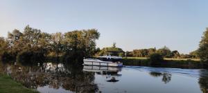 a boat is docked on a river at Camping belle rivière in Chaniers