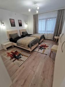 a bedroom with two beds and wooden floors at Vila Aras in Simeria