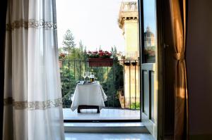une porte coulissante en verre avec une table sur un balcon dans l'établissement Don Giovanni Charme Apartment, à Catane