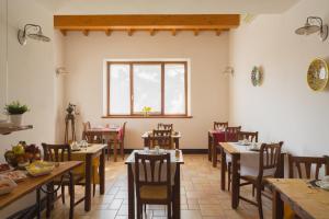 uma sala de jantar com mesas e cadeiras e uma janela em Le Vigne di Adamo em Volta Mantovana