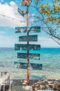 a sign on a pole near the ocean at Island Front - Bangcogon Resort and Restaurant in Oslob