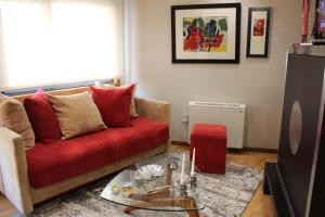 sala de estar con sofá rojo y mesa en Apartamento Spellos, en Rosal