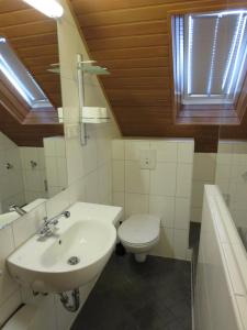 Baño blanco con lavabo y aseo en Ruhrzimmer, en Gelsenkirchen