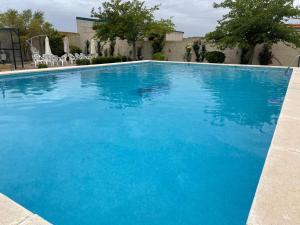 a large swimming pool with blue water at ESSE NATURA alojamientos & lifestyle in Pozohondo