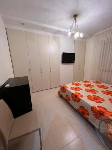 a bedroom with a bed and a chair and a tv at Appartamento Modugno centro (Bari) in Modugno