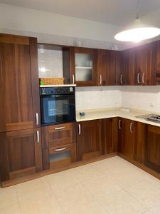 a kitchen with wooden cabinets and a black microwave at Appartamento Modugno centro (Bari) in Modugno