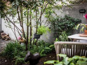 a garden with a table and trees and plants at Romantic Wellness BnB Noordwijk in Noordwijk aan Zee