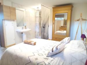 ein Schlafzimmer mit einem großen weißen Bett und einem Waschbecken in der Unterkunft Logement de charme in Coinches