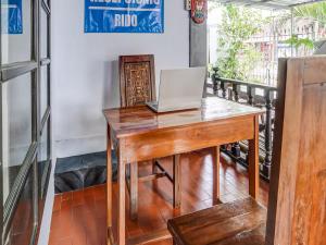 a wooden desk with a laptop on top of it at SPOT ON 90797 Sukun Syariah Homestay in Malang