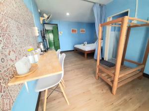 een kamer met een bureau en een kamer met een bed bij Talavera Hostel in Phitsanulok