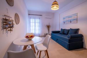 a living room with a blue couch and a table at Seaview Studios Kriopigi in Kriopigi