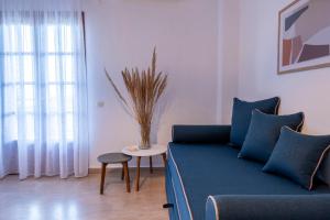 a living room with a blue couch and a table at Seaview Studios Kriopigi in Kriopigi