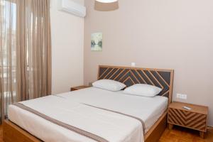 sypialnia z łóżkiem z białą pościelą i oknem w obiekcie Αριστοτέλους Comfy Apt. w Salonikach