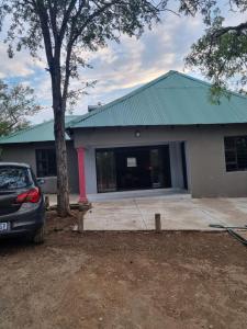 a house with a car parked in front of it at Unogwaja Rest in Marloth Park