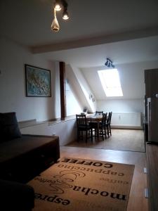 a living room with a table and chairs and a window at Apartmán Nerudovka in Kašperské Hory