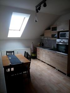 a kitchen with a dining room table and a skylight at Apartmán Nerudovka in Kašperské Hory