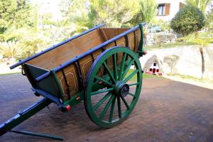a green and wooden bench sitting on a brick street at Hotel Quinta Do Furao in Santana