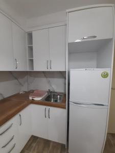 eine weiße Küche mit einer Spüle und einem Kühlschrank in der Unterkunft Lalzi Bay, Lura 3 apartament in Durrës