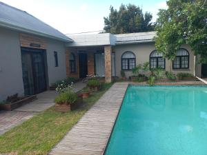 a house with a swimming pool in the yard at BARRY MICASA SELF CATERING ACCOMMODATION in Port Elizabeth