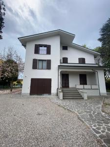 a white house with a driveway in front of it at Casa Bellodi in Novi di Modena