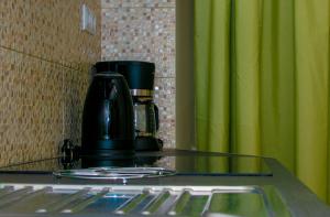 a coffee pot sitting on a glass table with forks at Corfu Old Town Gregory in Corfu Town