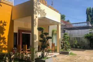 a house with trees and chairs in front of it at RedDoorz Syariah near Alun Alun Bima in Bima