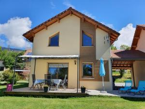 a house with a patio and an umbrella at Belle villa calme à la montagne in Saint-Michel-de-Chaillol