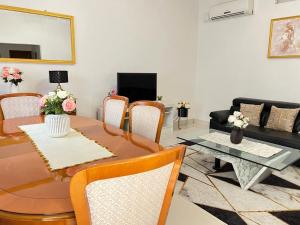 a living room with a table and chairs and a couch at Appartement meublé haut standing Bonamoussadi (Kotto) in Douala