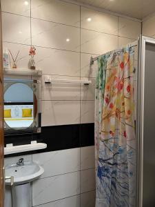 a bathroom with a sink and a shower curtain at Appartement meublé haut standing Bonamoussadi (Kotto) in Douala