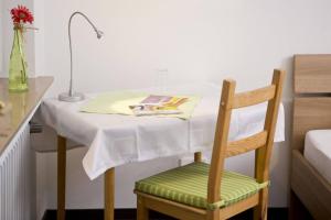 a table and a chair with a table and a lamp at Hotel Emmerich in Winningen