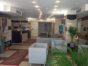 グラードにあるHotel Residence Sanremoの白い家具と植物のあるリビングルーム