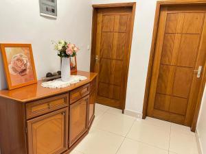 a bathroom with a vase of flowers on a wooden cabinet at Appartement meublé haut standing Bonamoussadi (Kotto) in Douala