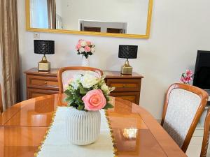 a dining room table with a vase of flowers on it at Appartement meublé haut standing Bonamoussadi (Kotto) in Douala