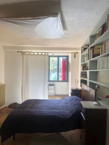 1 dormitorio con cama, escritorio y ventana en La Tinaia del Glicine, en Pratolino
